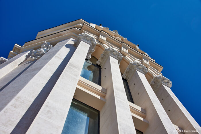 Palacio de Cibeles, Madrid A low-angle view of a white neoclassical building with tall columns and ornate decorations under a clear blue sky.