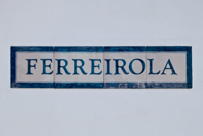 A rectangular ceramic sign with a blue border displays the word FERREIROLA in bold, blue capital letters against a white background.