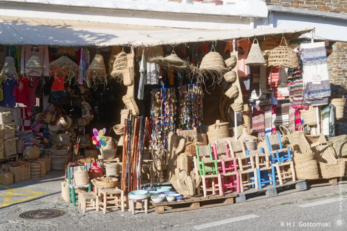Souvenir and craft shop A vibrant souvenir and craft shop with colourful textiles, hats, bags, and crafts displayed outside